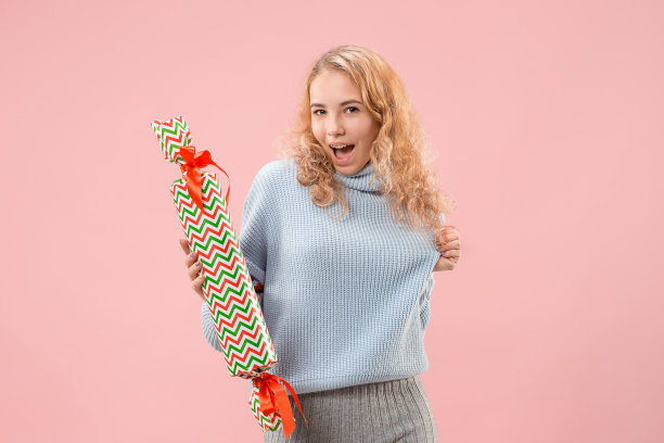 女人带着美丽的笑容拿着五颜六色的礼品盒。图片下载