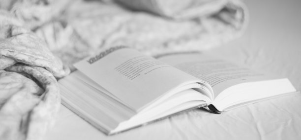 在床上看书，平静舒适的早晨心情照片，灰色和米色的毯子和床单。家庭生活方式图片下载