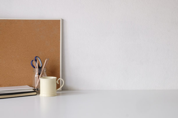 咖啡杯，笔记本，铅笔和办公用品与复印空间的白色桌子。图片下载