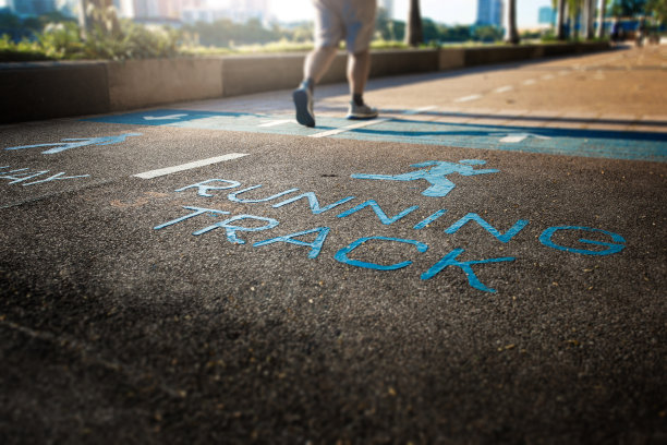 一个跑步者在公园的跑道上跑步。图片下载