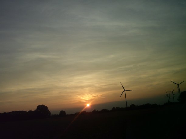 田园诗般的日落日出灰蓝橙粉蓝云景在黑暗的天际线与电动涡轮风车图片下载