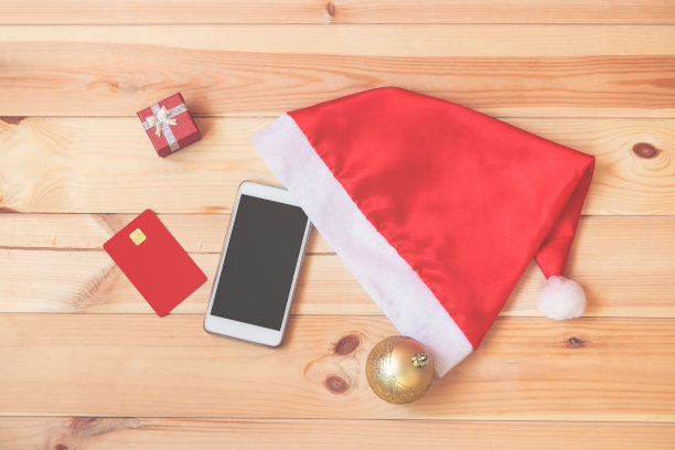 智能手机，圣诞帽，信用卡，圣诞球和礼物盒图片下载