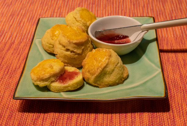 近景自制烤饼与草莓酱在水盘和彩色背景图片下载