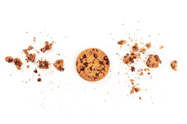 这是一张从上方拍摄的新鲜烘焙的金黄色巧克力曲奇饼，背景是白色的面包屑和复制空间图片下载