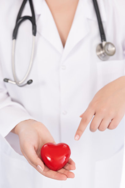 医学博士手捧红心形状的医院背景，医学概念图片下载