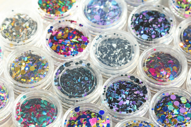 多色亮片设计的钉子在一个罐子。在jar闪闪发光。指甲用锡箔。组照片。闪闪美丽，闪闪发光。明亮的背景闪光。俯视图图片下载
