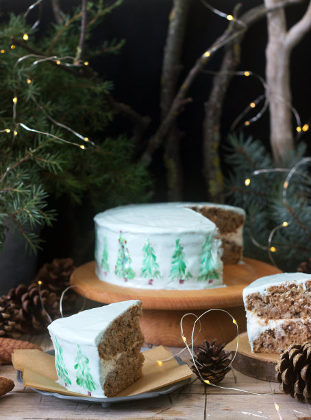 用彩绘的圣诞树装饰的庆祝蛋糕，背景是黑色的树枝和锥体。乡村风格。图片下载