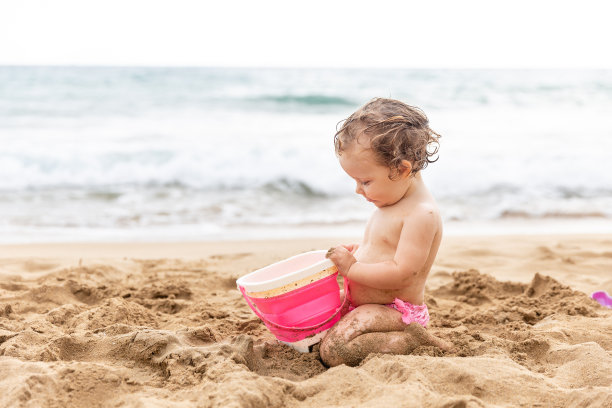 小女孩在玩水桶和沙子图片下载