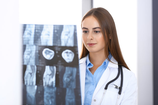 一位女医生站在医院窗户附近检查x光照片。在工作中的外科医生或整形外科医生医疗保健理念图片下载