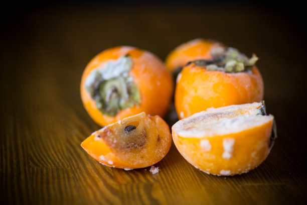 冰冻熟透的柿子放在冰块上图片下载