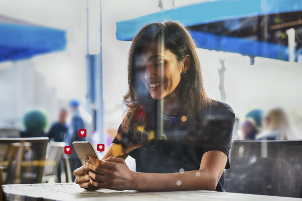 年轻女子使用带有社交媒体符号的智能手机图片下载