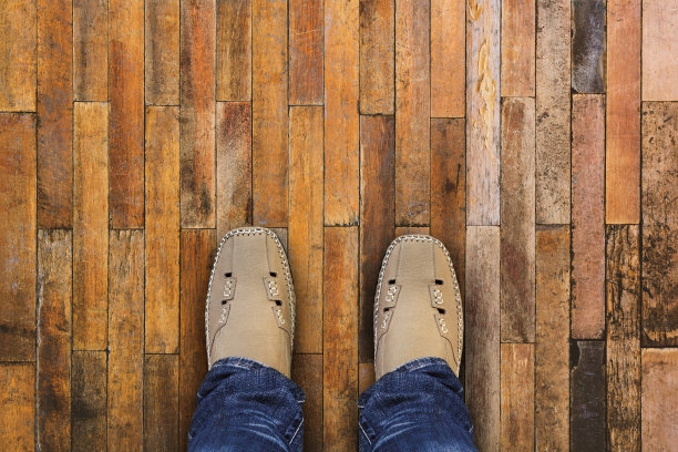 在旧木地板背景上的脚和鞋子俯视图图片下载