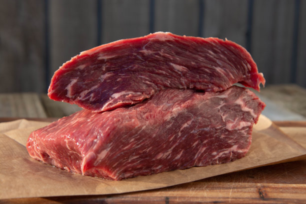 生肉，牛排放在质朴的木桌上，配上香料。图片下载