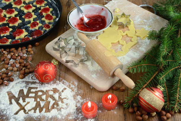 烤有装饰的圣诞饼干。面团和周围的装饰品。用面粉写圣诞快乐。图片下载