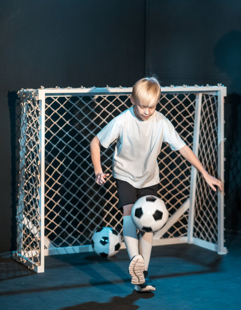 技巧娴熟的男孩足球运动员表演自由式足球图片下载