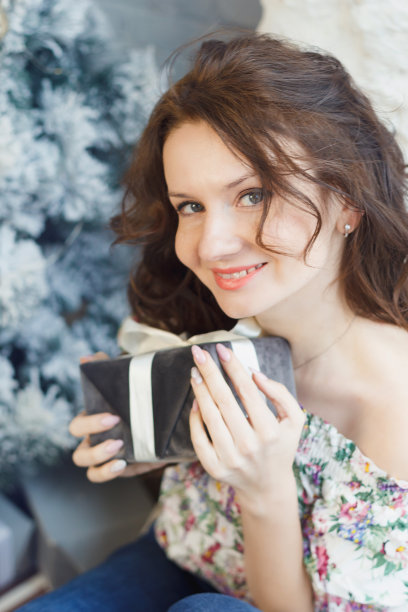 一位年轻的妇女手里拿着一份新年礼物。图片下载