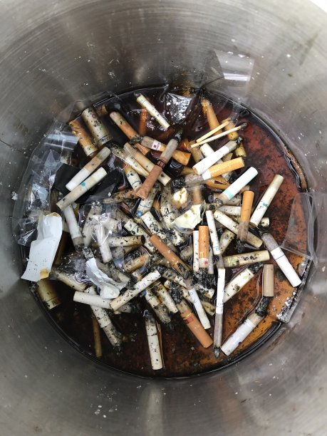 公共烟灰缸里的烟头图片下载