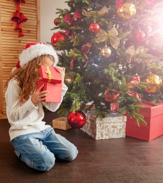 孩子带着礼物靠近圣诞树图片下载