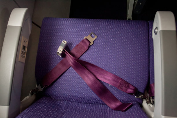 在飞机上系上安全带。暗色调和选择性聚焦。图片下载