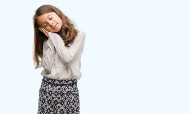 深色头发的西班牙裔女孩睡累了做梦和摆姿势与手在一起，而微笑闭上眼睛。图片下载