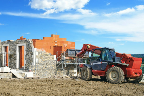 使用伸缩起重机建造石砌砖房。图片下载