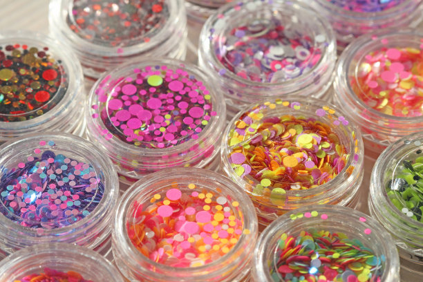 多色亮片设计的钉子在一个罐子。在jar闪闪发光。指甲用锡箔。组照片。闪闪美丽，闪闪发光。明亮的背景闪光。俯视图图片下载