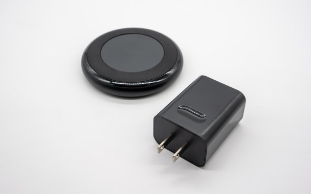 黑色圆形无线充电器和适配器隔离在白色背景上。图片下载