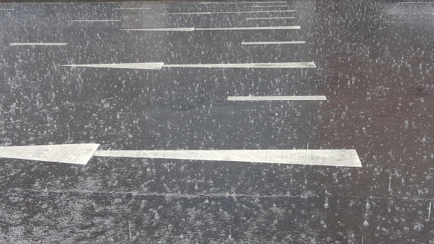 倾盆大雨时，大雨滴落在城市街道上图片下载