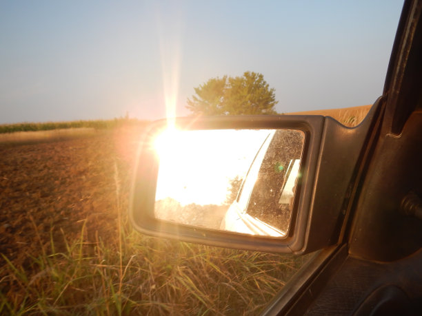 夕阳下的豆子映照在汽车的后视镜里图片下载