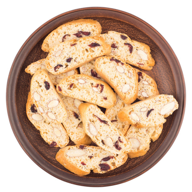 瓷盘里装着葡萄干和坚果饼干。孤立在白色背景上。前视图。图片下载