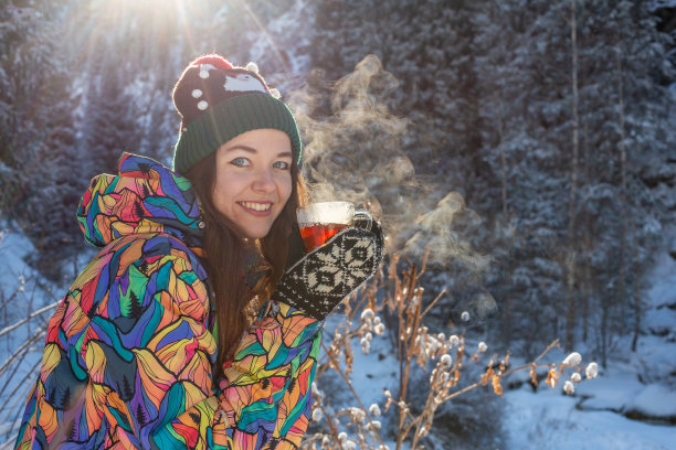 女孩喜欢下雪。下雪的时候，一名穿着针织衣服的年轻女子正在森林里喝茶。健美的照片图片下载