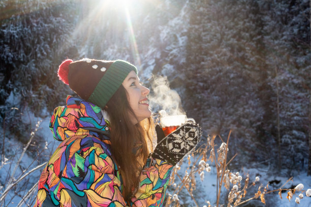 女孩喜欢下雪。下雪的时候，一名穿着针织衣服的年轻女子正在森林里喝茶。健美的照片图片下载