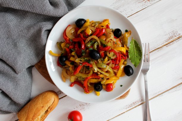 用白盘子里的橄榄烤黄、绿、红辣椒。图片下载