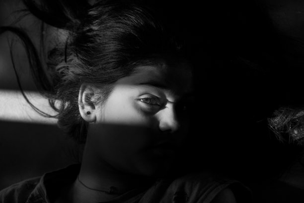 阳光的阴影在女孩的脸上图片下载