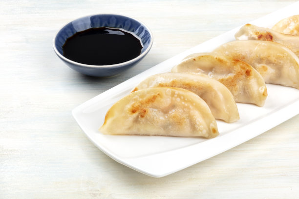 一张加了酱油的亚洲饺子的特写照片，放在一张质朴的木桌上，桌子上有一个放文字的地方图片下载