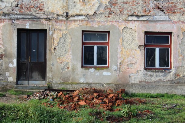废弃废弃的房子，前门和窗户的特写，部分倒下的正面图片下载