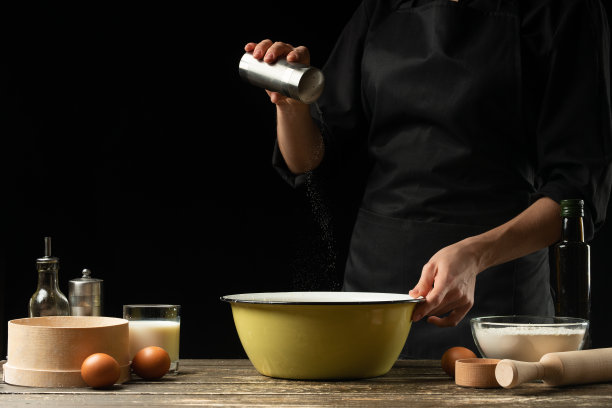 专业厨师为面包，意大利披萨，派，意大利面，美国煎饼，俄罗斯煎饼和糖果准备面团。水平的照片。在黑色背景上，为设计图片下载