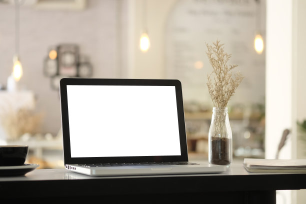 模型笔记本电脑上模糊的咖啡馆背景。图片下载