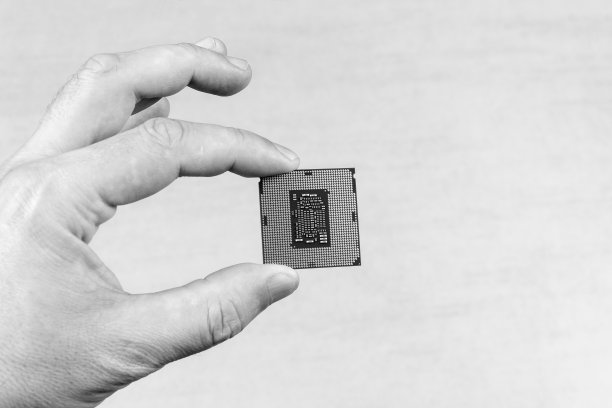 手持手指的男子桌面处理器第8代灰色背景特写俯视图，黑白照片图片下载