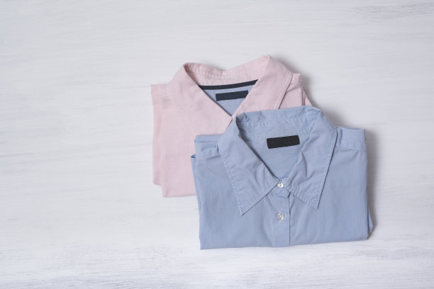 两件折叠的衬衫放在木制背景上。空间的文本。时尚的概念图片下载