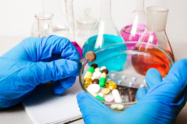 持有药丸的背景化学实验室和试剂。非法药丸，药品生产在实验室。药物发现。药理学和生物技术概念图片下载