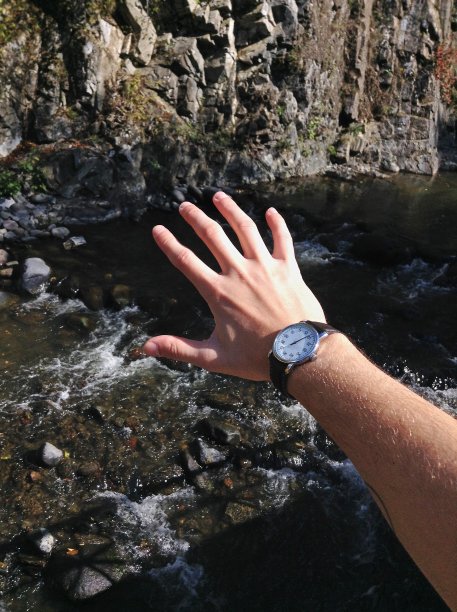 一个男人的手在山河的背景上。男游客和旅行家周末在山里旅游时都有帮助。图片下载