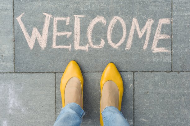 灰色的人行道上，女人的脚上写着欢迎的文字图片下载
