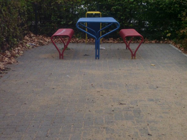 靠近金属蓝色的桌子和红色的公园长椅图片下载