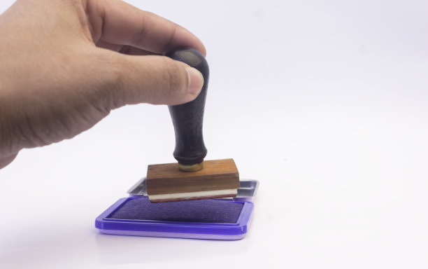 木图章用手握图章，在蓝色油墨上孤立白色图片下载