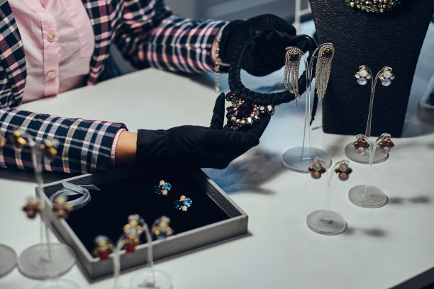 一名珠宝工作人员在一家珠宝店展示一串昂贵的宝石项链的特写照片。图片下载