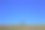 在美丽的、阳光明媚的秋日，一个成年的徒步旅行者站在草地上的地平线上图片下载