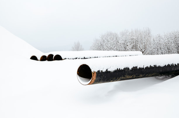 管道敷设在沟槽内。冬天的季节。图片下载