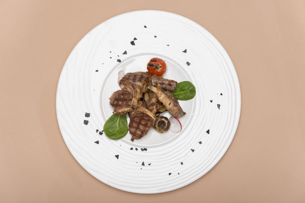 美味的烤羊排配烤番茄，配以小萝卜、嫩菠菜和绿叶图片下载