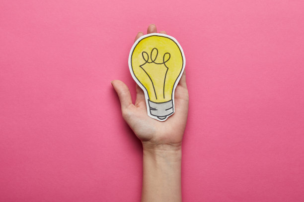 顶视图的黄色灯泡的想法符号在粉红色的背景图片下载